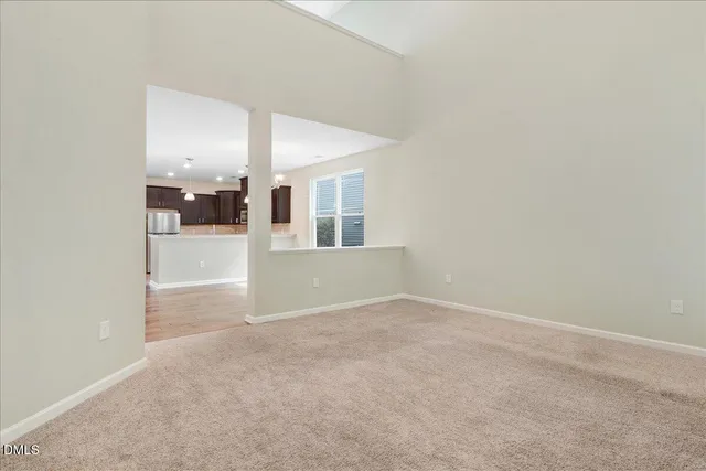 an empty room with windows and fireplace