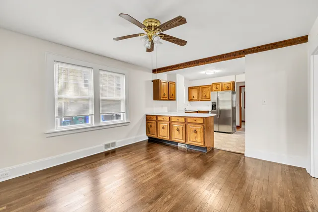 a living room with stainless steel appliances kitchen island granite countertop a stove and a large window