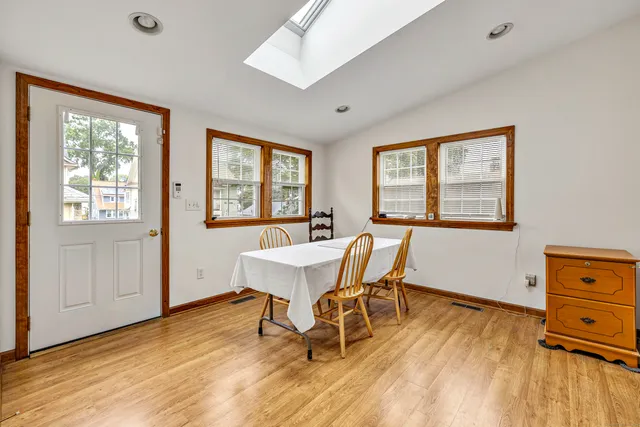 a dining room with wooden floor and a window
