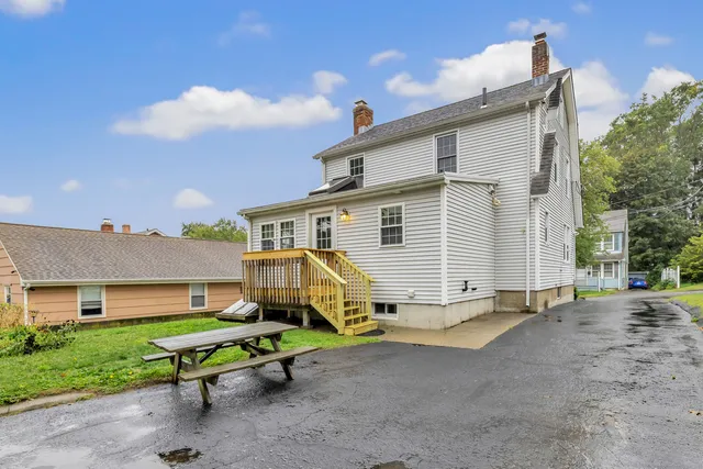 a view of a house with a yard and sitting area