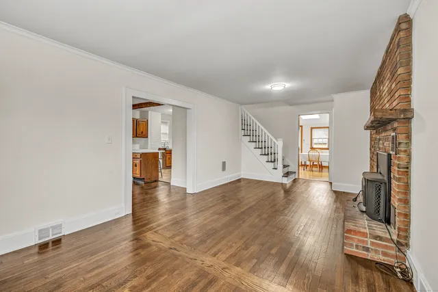 a view of empty room with wooden floor and fireplace