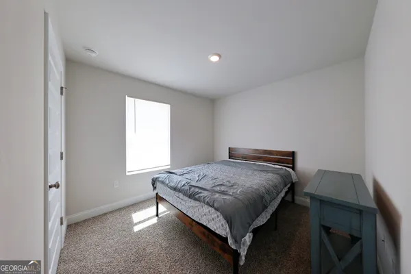 a bed sitting in a bedroom next to a window