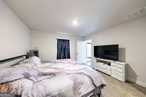 a bedroom with bed and tv with wooden floor