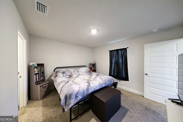 a bed sitting in a bedroom next to a window