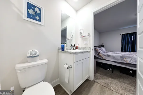 a bathroom with a granite countertop toilet sink and mirror