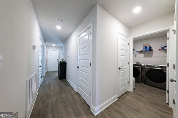 a view of a hallway and a bedroom with wooden floor