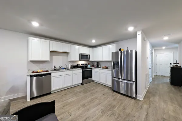 a kitchen with stainless steel appliances granite countertop a refrigerator sink and stove