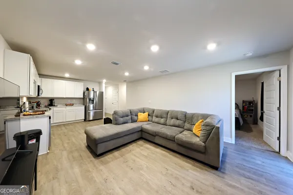 a living room with furniture and a wooden floor
