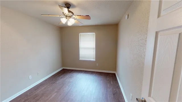 a view of a room with wooden floor and fan