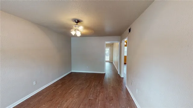 a view of a hallway with wooden floor and a chandelier