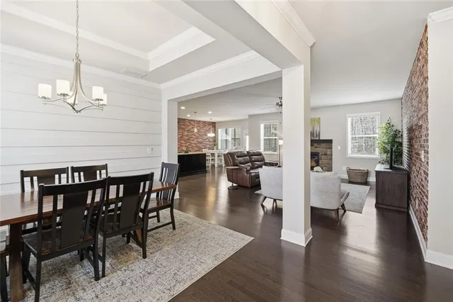 a view of a dining room and livingroom with furniture wooden floor a chandelier