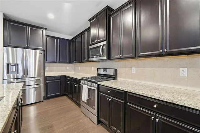 a kitchen with granite countertop stainless steel appliances and wooden cabinets
