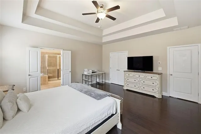 a bedroom with a bed tv on table and a flat screen tv