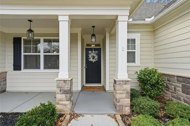 a front view of a house with a glass windows and potted plants