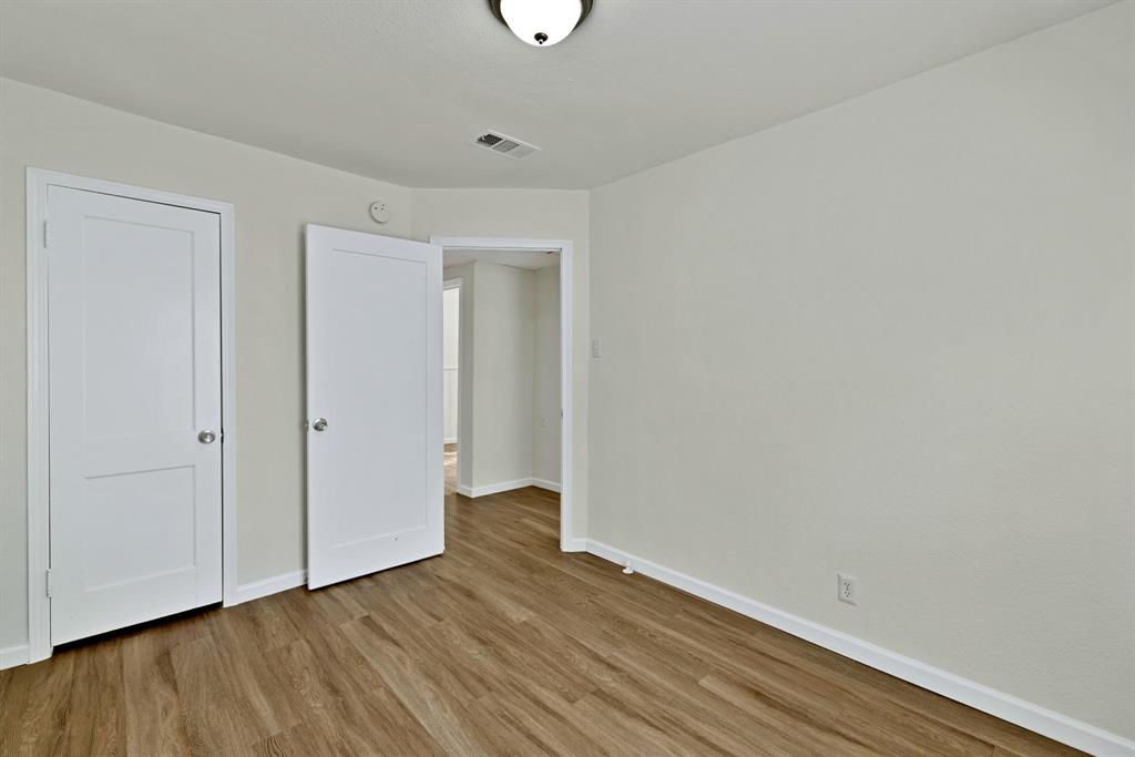 613 Cheyenne Road Dallas, TX 75217 - Photo 14 of 28 Neutral-toned room featuring light wood-finish flooring, white baseboards, and a flush mount ceiling light