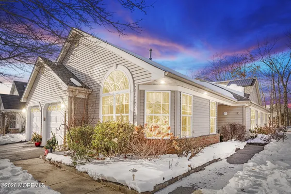 a view of a white house with a yard covered in snow