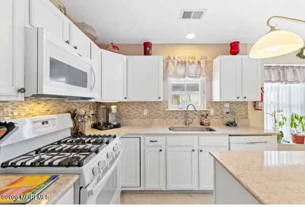 a kitchen with a sink a stove and cabinets