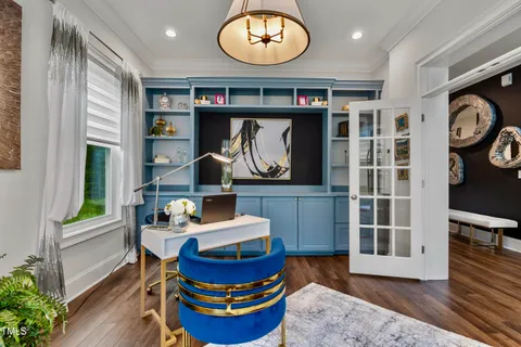 a view of a dining room with furniture a chandelier and wooden floor