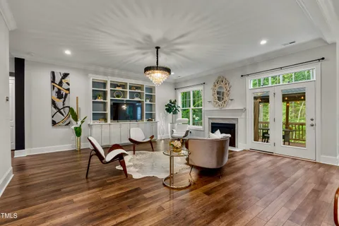 a living room with furniture a fireplace and a floor to ceiling window
