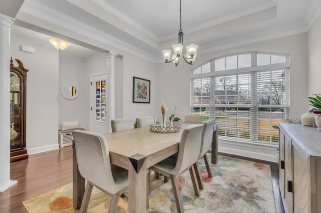 a view of a dining room with furniture a chandelier and wooden floor
