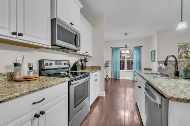 a kitchen with granite countertop stainless steel appliances and white cabinets