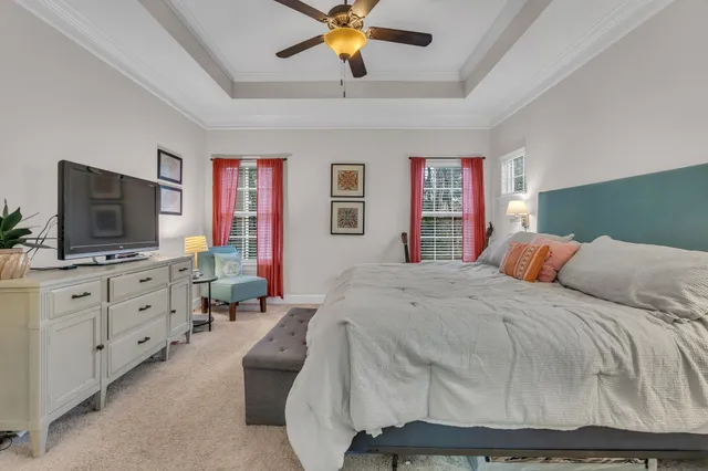 a bedroom with a large bed and a flat tv screen on dresser