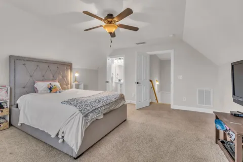a spacious bedroom with a bed and a chandelier