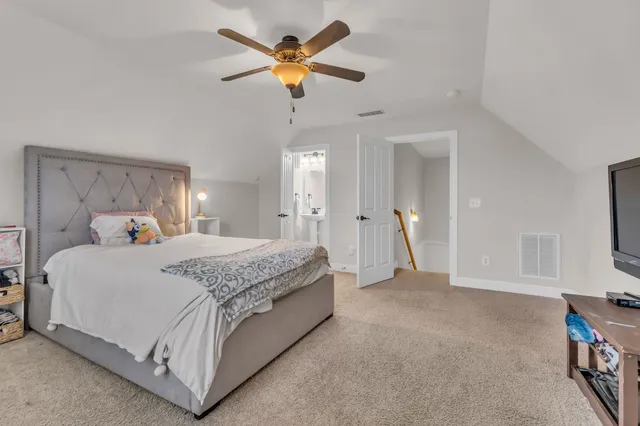 a spacious bedroom with a bed and a chandelier