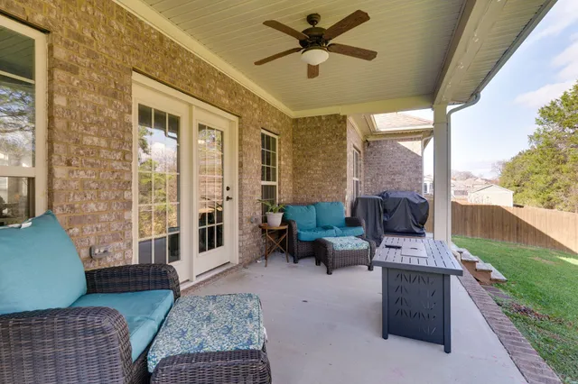 a living room with patio furniture and a floor to ceiling window