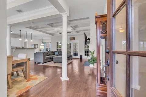 a living room with furniture and a table with wooden floor