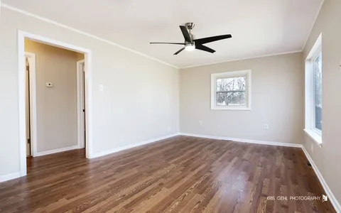 a view of a big room with wooden floor closet and windows