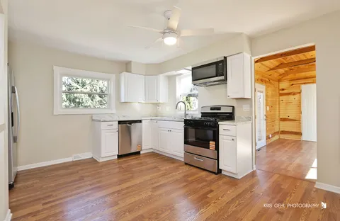 a kitchen with granite countertop a refrigerator stove top oven and sink