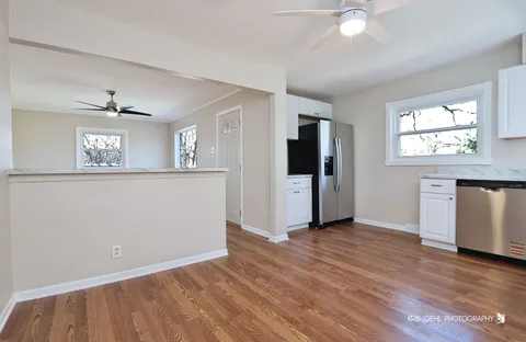 a view of a kitchen with wooden floor and electronic appliances