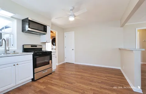a kitchen with stainless steel appliances a white cabinet and a stove top oven
