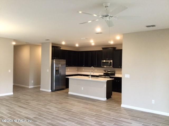 51 Seamount Way St. Augustine, FL 32092 - Photo 3 of 24 a kitchen with kitchen island stainless steel appliances a stove refrigerator sink and cabinets