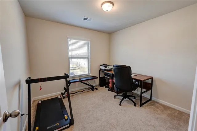a view of a workspace with furniture and a window