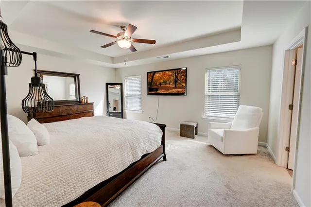 a bedroom with a bed a couch and a flat screen tv