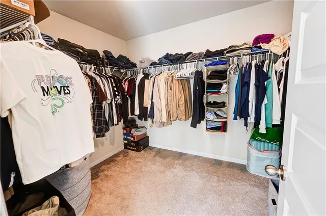 a view of walk in closet with clothes and shoes