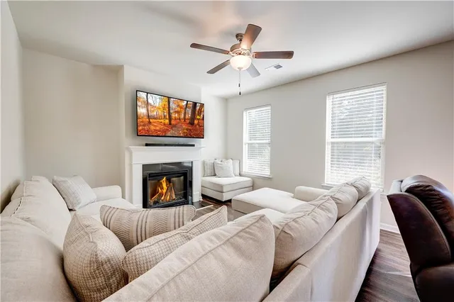 a living room with furniture a fireplace and a flat screen tv