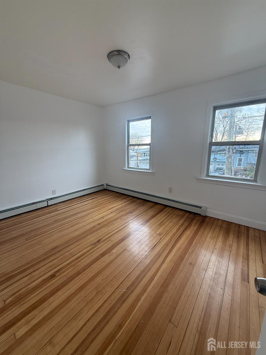 579 Florida Grove Road Perth Amboy, NJ 08861 - Photo 5 of 14 a view of an empty room with wooden floor and a window