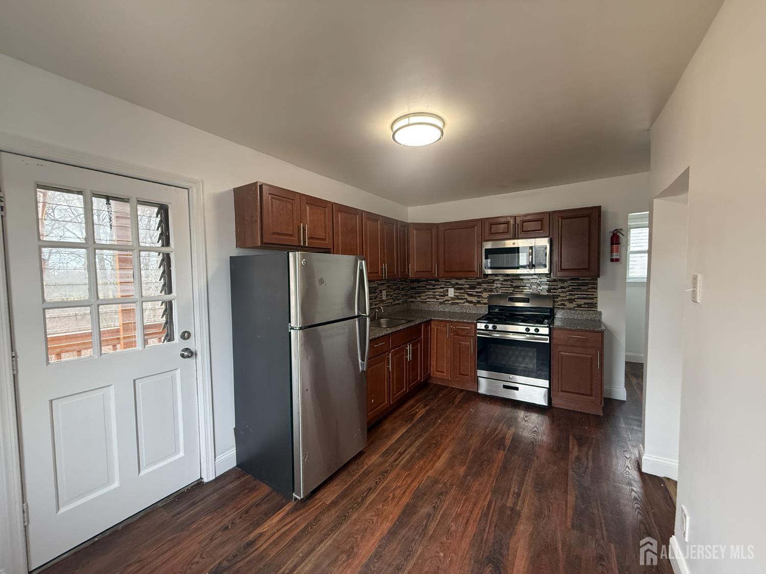 579 Florida Grove Road Perth Amboy, NJ 08861 - Photo 9 of 14 a kitchen with stainless steel appliances a refrigerator and a stove top oven