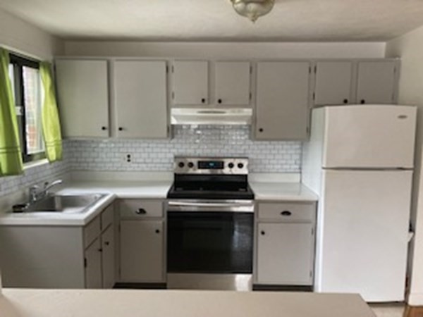 a kitchen with a stove sink and refrigerator