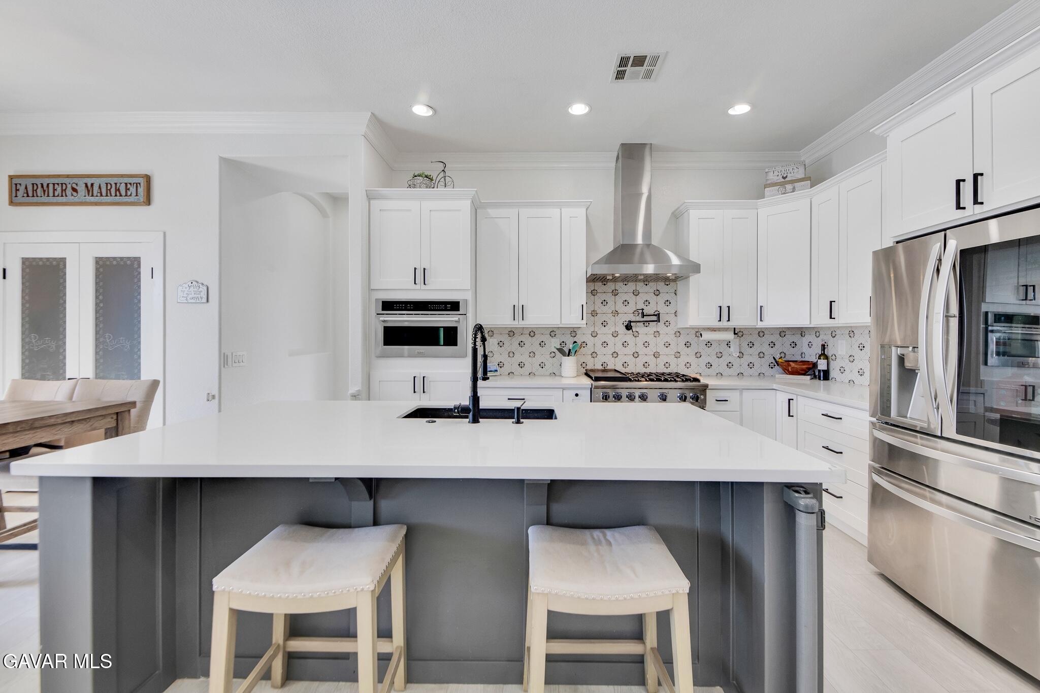 41632 Firenze Street Lancaster, CA 93536 - Photo 16 of 67 a kitchen with kitchen island granite countertop a table and chairs in it