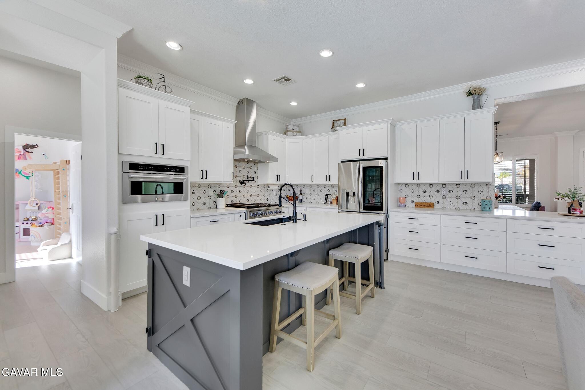 41632 Firenze Street Lancaster, CA 93536 - Photo 17 of 67 a kitchen with white cabinets and stainless steel appliances