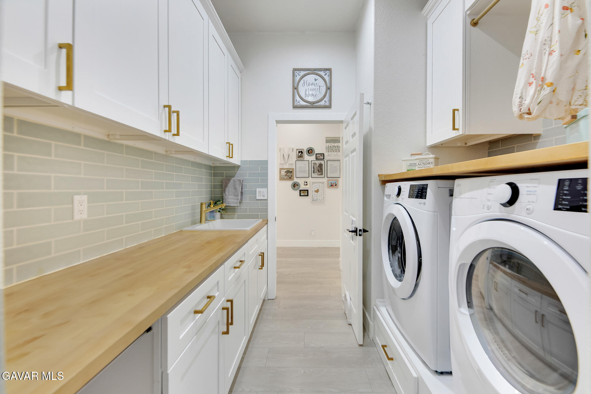 41632 Firenze Street Lancaster, CA 93536 - Photo 36 of 67 a bathroom with a sink a washer and dryer