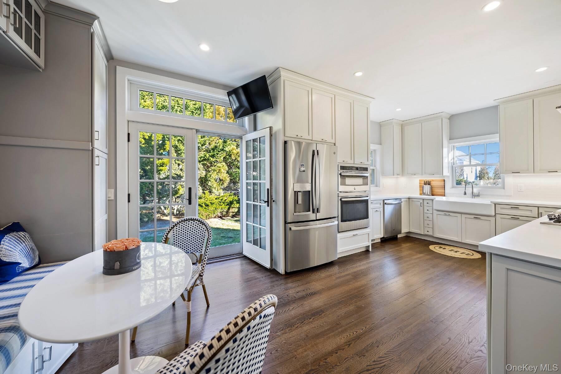 30 Exchange Place Westhampton Beach, NY 11978 - Photo 12 of 25 a kitchen with stainless steel appliances a stove a refrigerator a sink a dining table and chairs