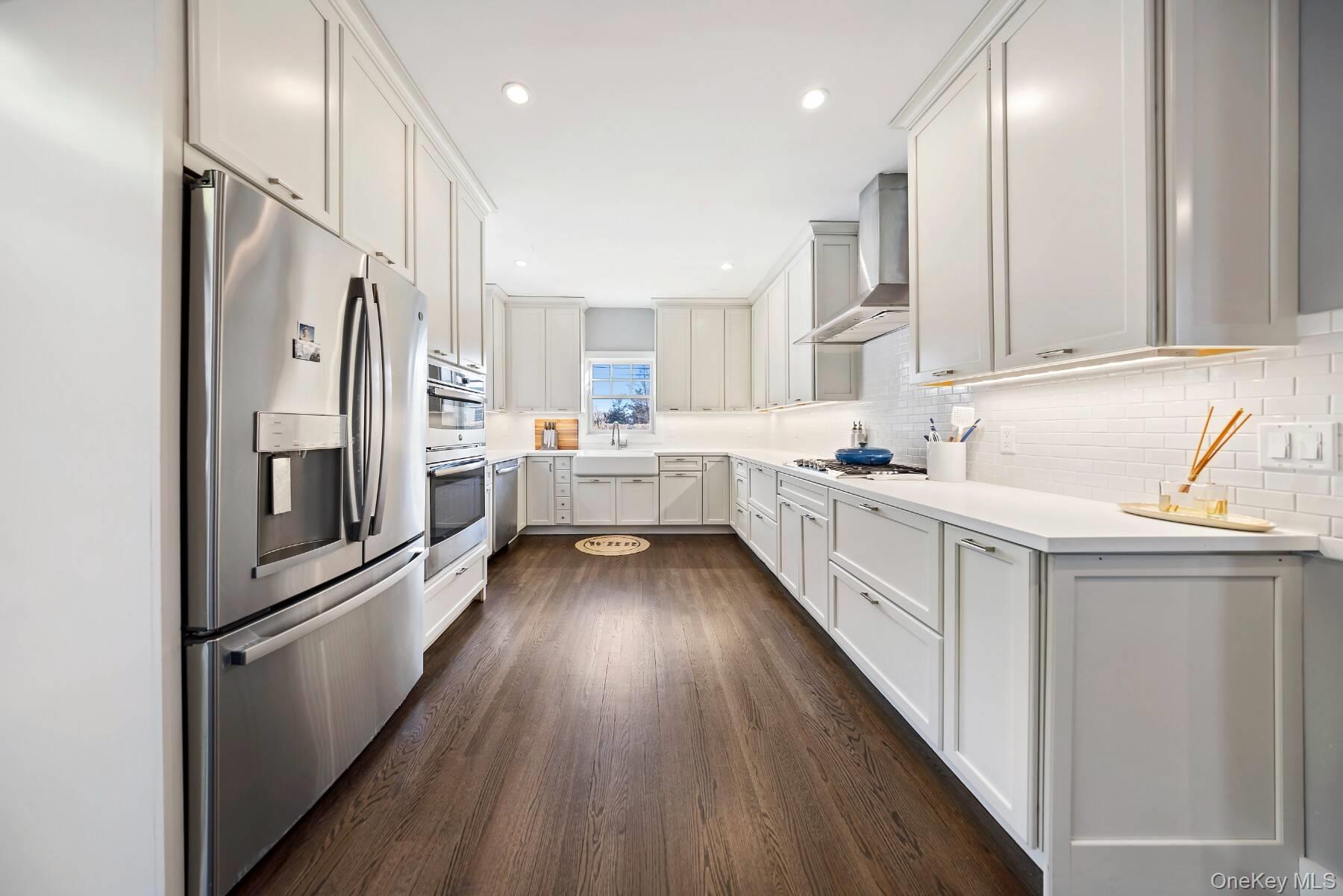 30 Exchange Place Westhampton Beach, NY 11978 - Photo 9 of 25 a kitchen with refrigerator cabinets and wooden floor