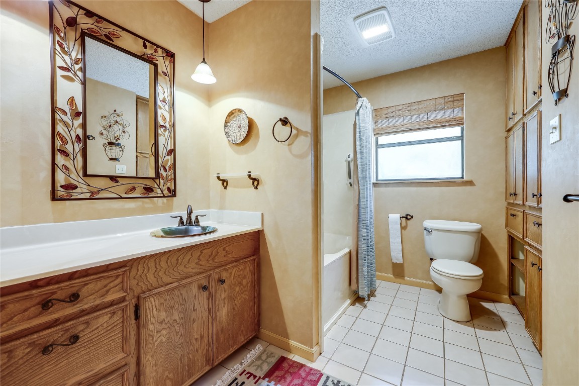 6015 Tonkowa Trail Georgetown, TX 78628 - Photo 21 of 40 a bathroom with a granite countertop sink a toilet and a mirror