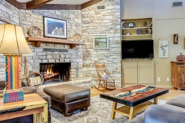 a living room with furniture a flat screen tv and a fireplace