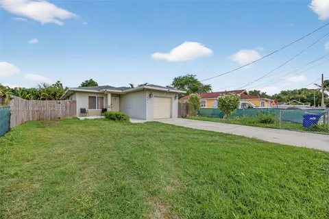 a view of a house with a backyard and a garden
